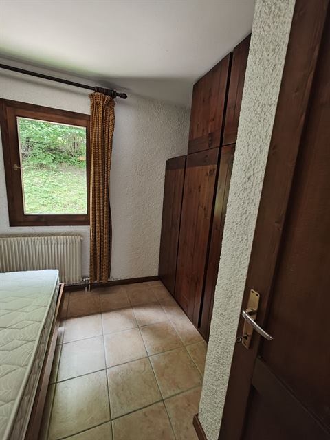 Camera da letto con armadio in legno e pavimento pulito, dopo la pulizia